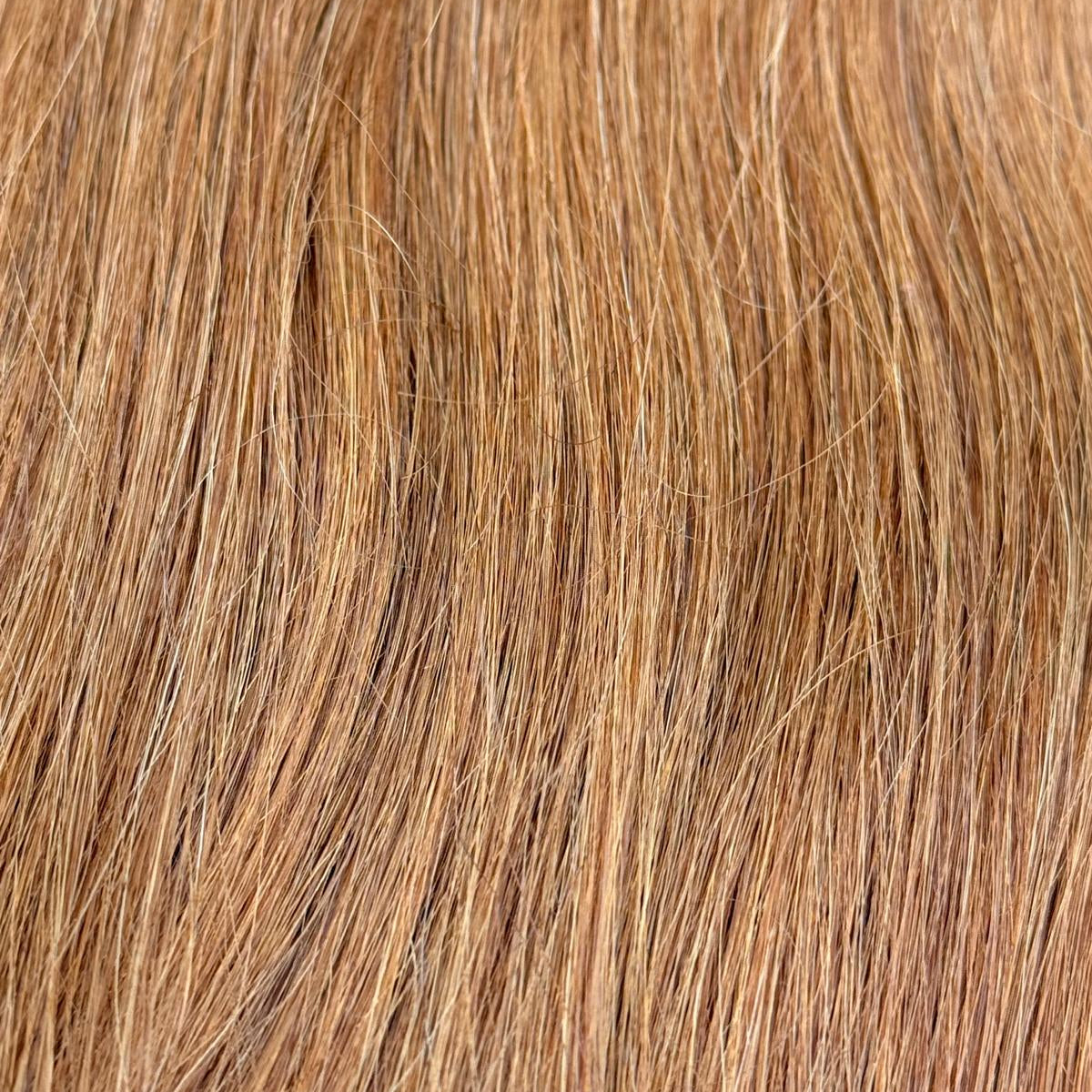 Nahaufnahme der Echthaar-Struktur von Machine Weft Tressen in hellem Kupferblond