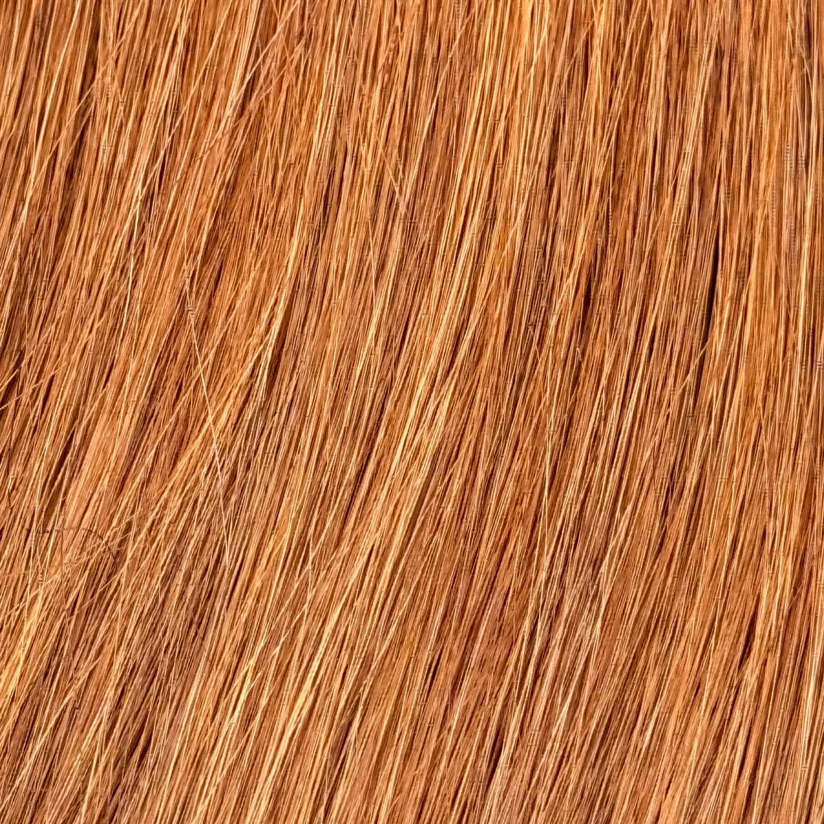 Nahaufnahme der Echthaar-Struktur von Machine Weft Tressen in warmem Caramelblond