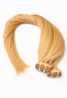 Premium Echthaar Tape-Ins von ROVIA Hair für eine professionelle Haarverlängerung in einem hellen Goldblond.
