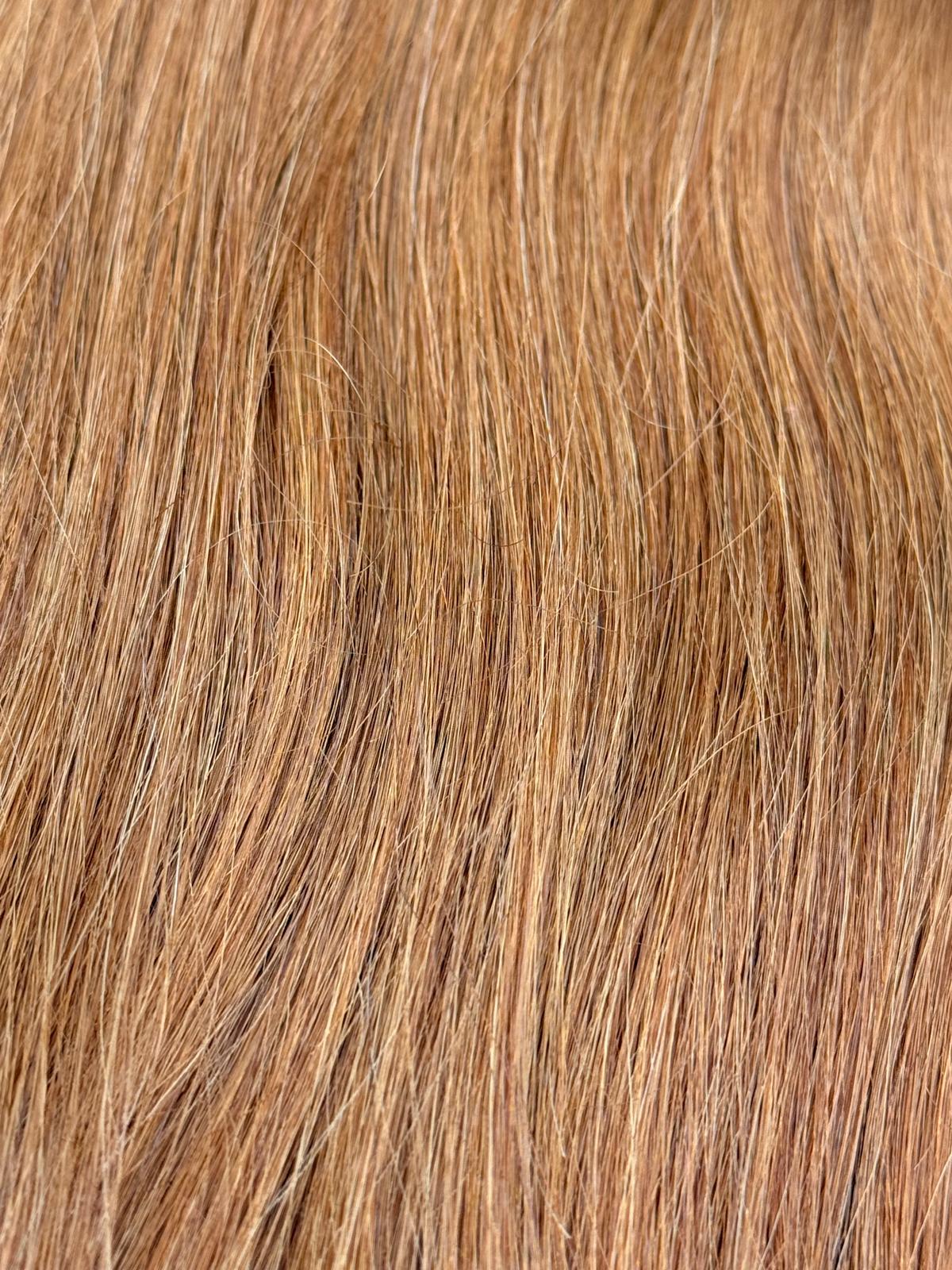 Nahaufnahme der Echthaar-Struktur von Machine Weft Tressen in hellem Kupferblond