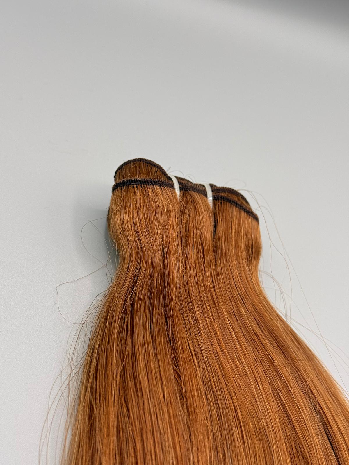 Nahaufnahme der Tressennaht einer Machine Weft in hellem Kupferblond von ROVIA Hair