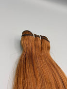Nahaufnahme der Tressennaht einer Machine Weft in hellem Kupferblond von ROVIA Hair