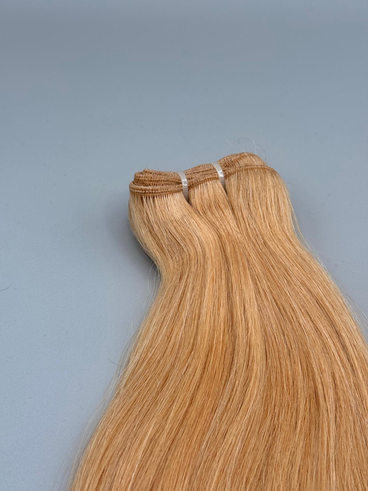 Nahaufnahme der Tressennaht einer Machine Weft in Goldblond von ROVIA Hair
