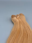 Nahaufnahme der Tressennaht einer Machine Weft in Goldblond von ROVIA Hair