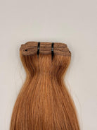 Nahaufnahme der Tressennaht einer Machine Weft in warmem Caramelblond von ROVIA Hair